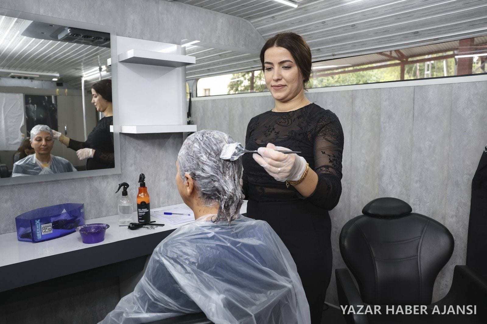 Mersin Büyükşehir Belediyesinin mobil kuaför aracında bir vatandaşa saç boyama hizmeti veriliyor (Fotoğraf: Mersin Büyükşehir Belediyesi)