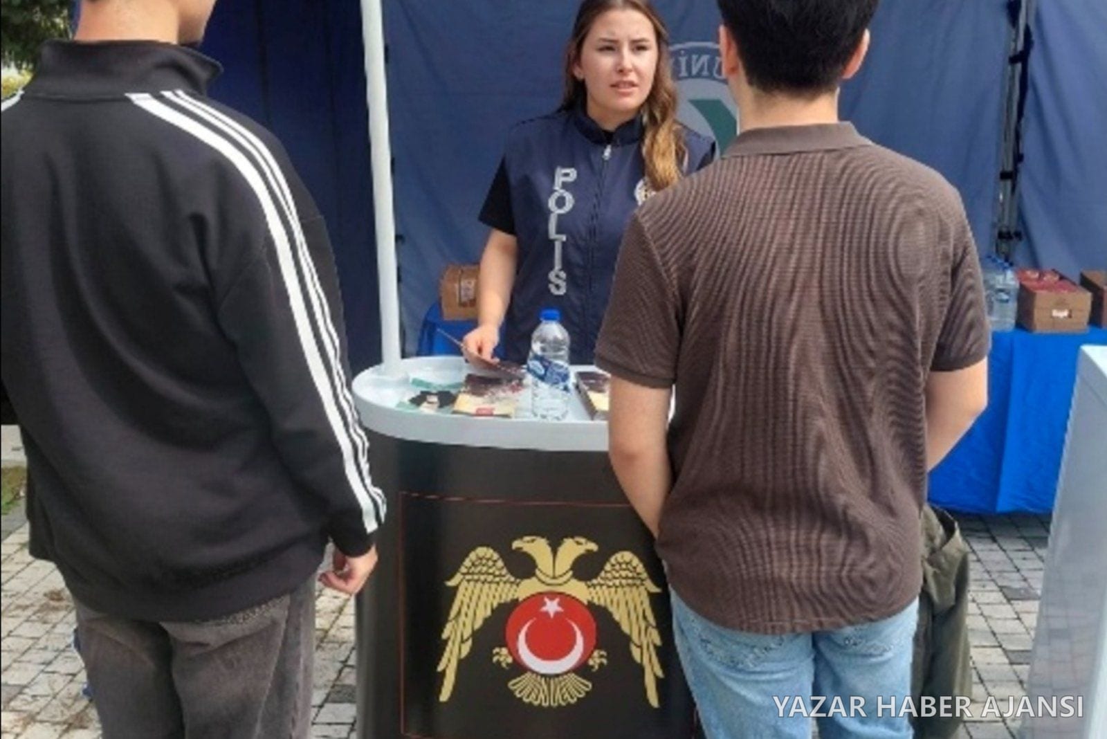 Giresun'da okul güvenliği çalışmaları kapsamında kurulan stantta bir polis memuru öğrencileri bilgilendiriyor (Fotoğraf: Giresun Valiliği)